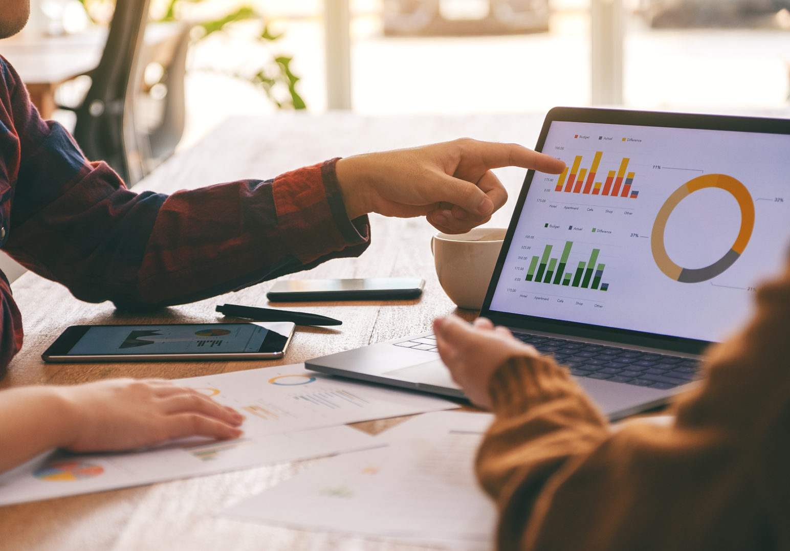 Image of a person pointing at a bar graph on a computer screen with another person's hand in the picture. Header for Data careers