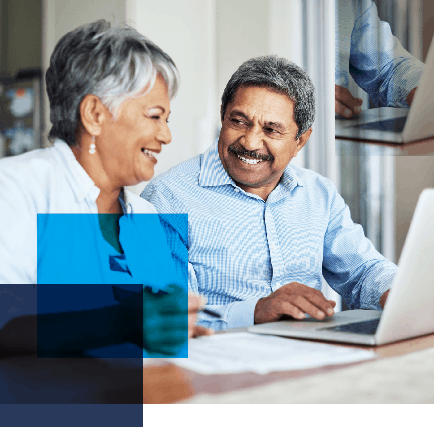 Image of an older couple sitting in front of a laptop smiling at each other. Related to: improving efficacy, pbgc efficacy, pbgc user experience, updating pbgc