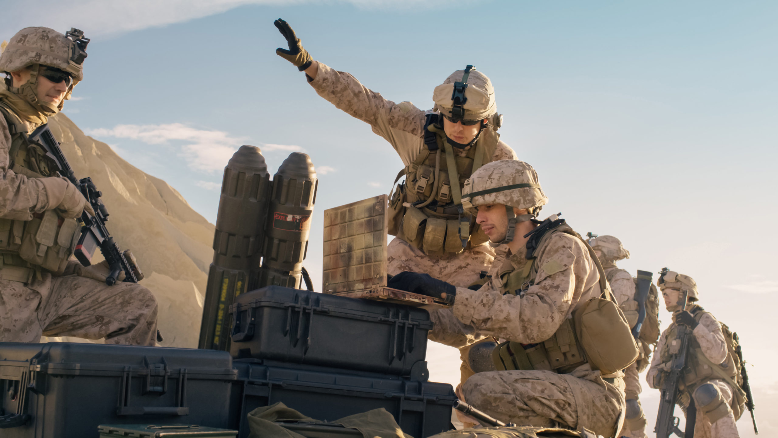 Image of two soldiers in camouflage gear on a field laptop. Related to: national security sector, counter cyber terrorism, digital warfare, cyber warfare, cyber warfare operations, digital war room,