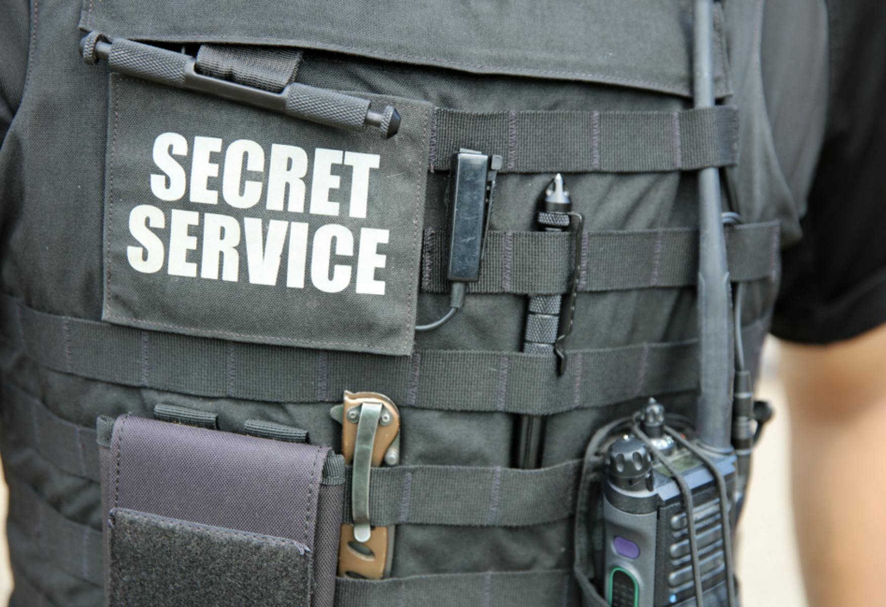 Image shows chest of a person with a bullet proof vest and the words 'secret service' on it. Related to: cybercrime, cybercrimes, financial cybercrimes, AI, AI automation, Artificial intelligence initiative, analyzing data records, automated data record system, law enforcement ai integration, federal agency ai integration.