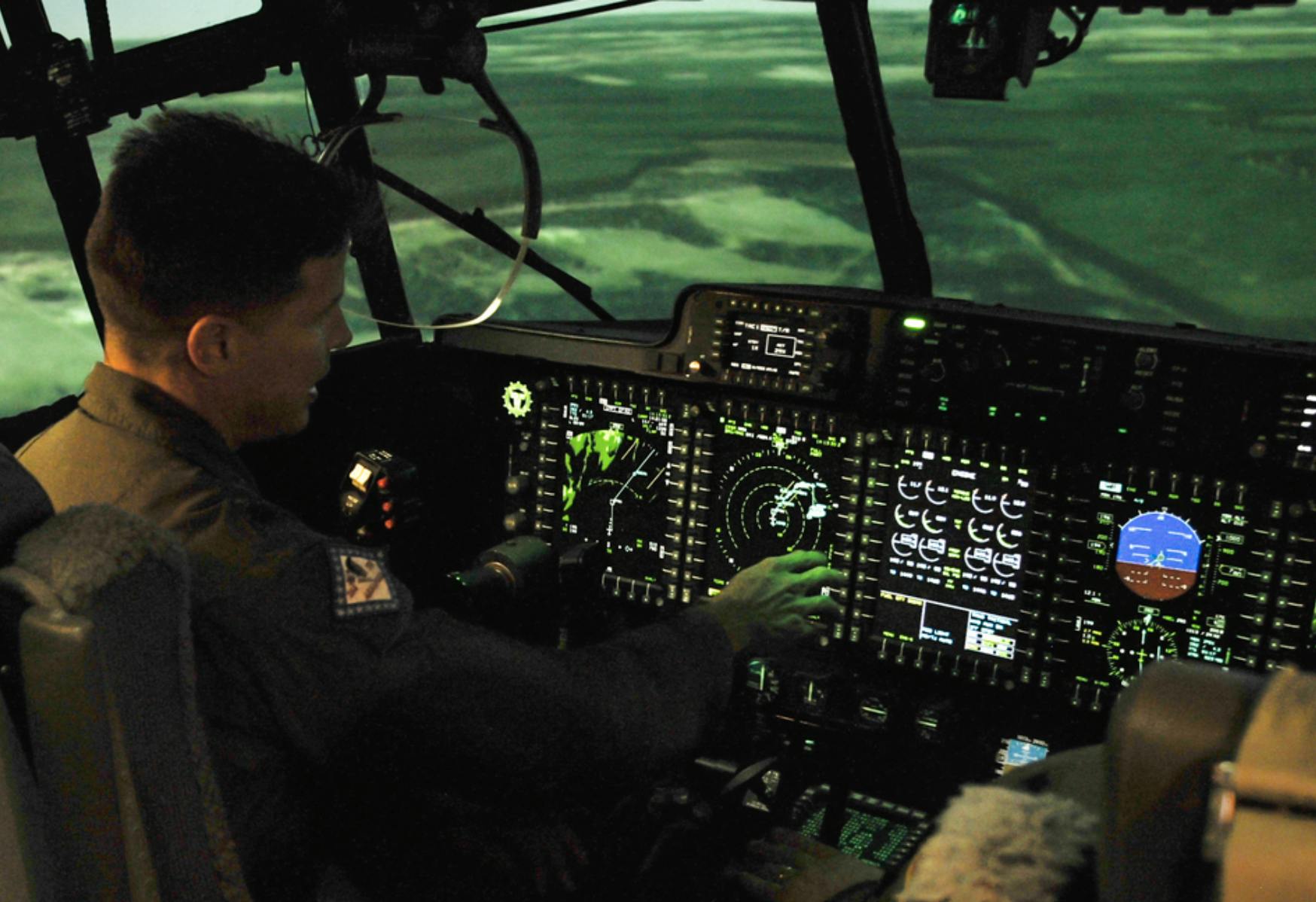 Image shows a cockpit with a pilot and the background an aerial view of coastline. Related to: artificial intelligence, air force user experience, AI development air force, air force software factories, DISA, emerging technology, secure network.