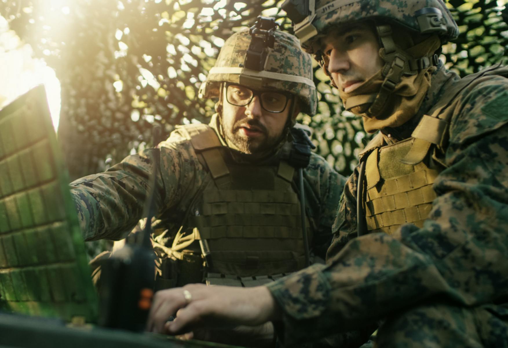 Image of two soldiers in camouflage and gear in a tent, consulting over a laptop screen. Related to: Army Digital Transformation Strategy, Army CIO Raj Iyer, unified network, digital transformation strategy, army software factory, army digital engineering strategy, digital transformation plan, army data engineering.