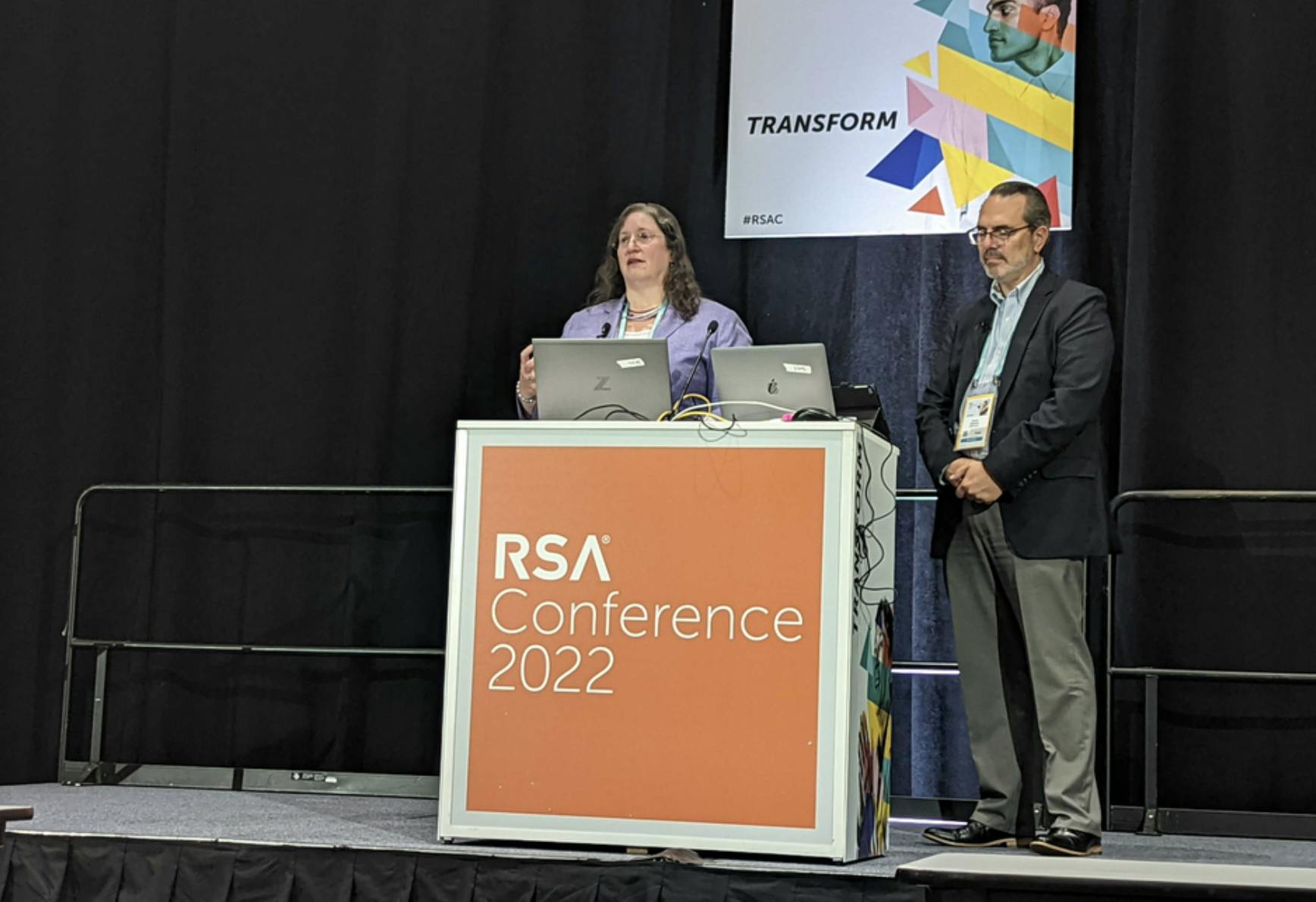 Image of a man and woman at a podium onstage at RSA Conference 2022. Related to: DOE, Department of Energy, national cyber-informed engineering strategy, national cyber engineering strategy, legacy and future infrastructure, five pillar strategy.