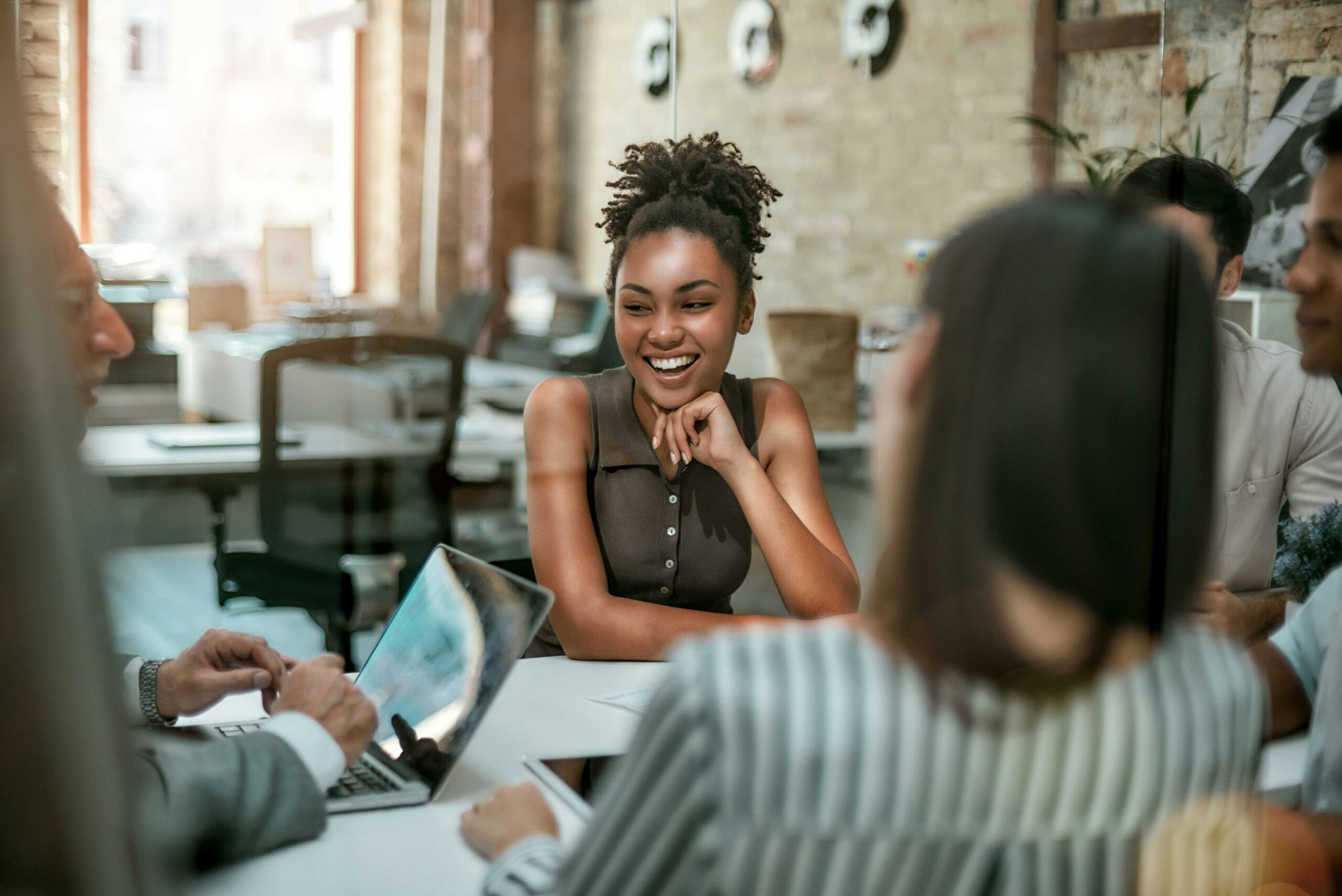 Woman sitting at a conference table with her coworkers