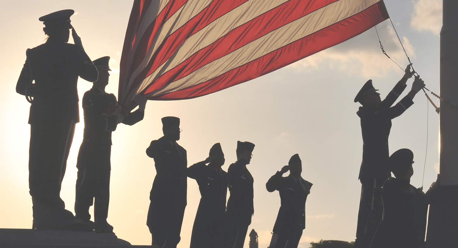 Military veterans raising an American flag